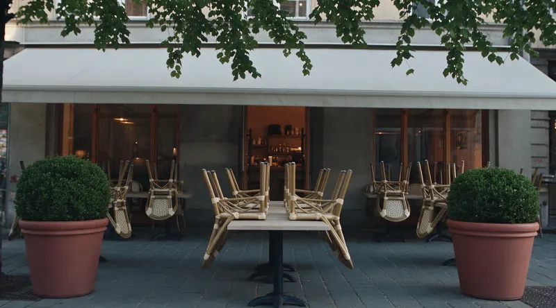 Caféterrassen ved fyraften: stolene står op ad bordene, og der er ingen gæster.